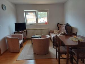 a living room with a couch and a table and a tv at Apartment Kalpačina in Žabljak