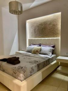 a bedroom with a bed with a headboard and pillows at Harmony by the Sea in Chalkida