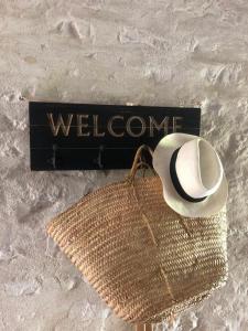 a hat and a welcome sign and a purse at Chambres de charme avec jardin et piscine in Coulonges-sur-lʼAutize