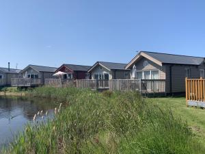a row of houses next to a body of water at The Lake House, The Bay Filey, sleeps 4 in 2 double rooms with ensuites, 1 dog welcome in Filey