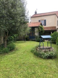 a yard with a table in front of a house at Chambres de charme avec jardin et piscine in Coulonges-sur-lʼAutize