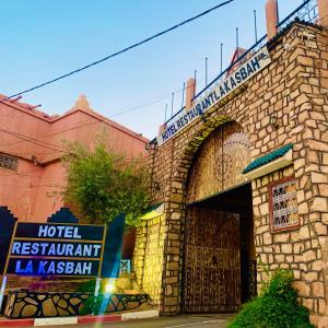 un restaurante del hotel con una señal frente a un edificio en Hotel Restaurant La Kasbah en Tinerhir