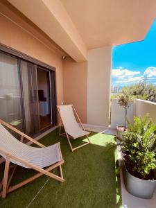 アテネにあるAthens Riviera 2-Bed Apt & Pool Access #Unoblu®の椅子2脚とバルコニーが備わる客室です。