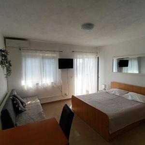um quarto com uma cama, um sofá e janelas em Apartments Monika Omiš em Omiš