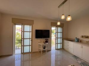 a kitchen with a tv on the wall and a table at צימרימון in Bet Rimmon