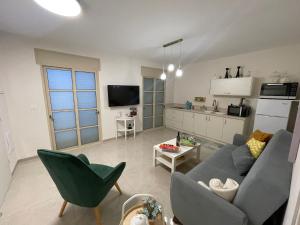 a living room with a couch and a kitchen at צימרימון in Bet Rimmon