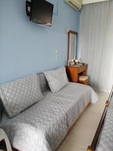 Un dormitorio con una cama y un televisor en la pared. en Star Apartment, en Kallithea Halkidikis