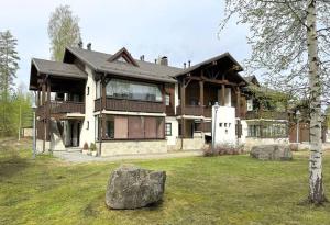 uma casa grande com uma pedra em frente em Yläkerran asunto parvekkeella ja saunalla em Tahkovuori