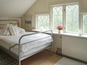 1 dormitorio con 1 cama y 2 ventanas en Holiday home Djursholm, en Danderyd
