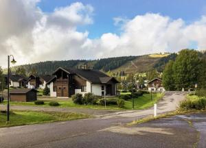 ein Haus an der Seite einer Straße mit einem Berg in der Unterkunft Yläkerran asunto parvekkeella ja saunalla in Tahkovuori