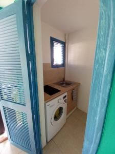 a laundry room with a washing machine and a sink at West Indies in Caritan