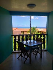 een tafel en stoelen op een balkon met uitzicht bij West Indies in Caritan