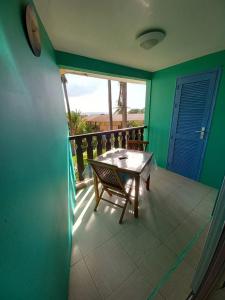 a table and a chair on a balcony with a window at West Indies in Caritan