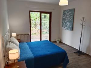 sypialnia z niebieskim łóżkiem i oknem w obiekcie Brezza Marina Studios w mieście Montesilvano