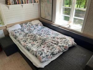 Bett mit Blumendecke in einem Zimmer mit Fenster in der Unterkunft Blueberry Hill in Skånes Fagerhult
