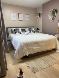 a bedroom with a large bed with a teddy bear on it at Petite maison hyper centre de Dieppe proche plage in Dieppe