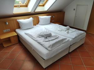 a bedroom with a bed with white sheets and pillows at Ferienwohnung Leuchtturm in Dewichow