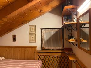 a small bedroom with a bed and a window at Appartamento Fronte Piste in Auronzo di Cadore