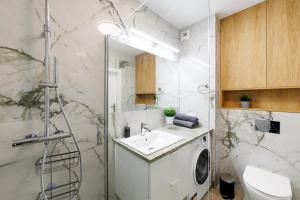 a bathroom with a washing machine and a sink at Apartament Marinus ProstyWynajem Gdańsk Brzeźno in Gdańsk