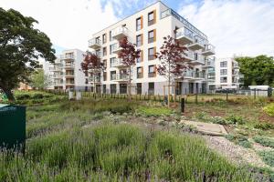 an apartment building with a garden in front of it at Apartament Marinus ProstyWynajem Gdańsk Brzeźno in Gdańsk