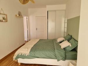 - une chambre avec un lit doté de draps et d'oreillers verts dans l'établissement Chez Sara et Joan : T2 hypercentre, cosy proximité gare, à Orléans