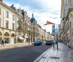 une rue de la ville avec des voitures garées dans la rue dans l'établissement Chez Sara et Joan : T2 hypercentre, cosy proximité gare, à Orléans