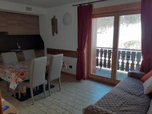 un soggiorno con tavolo e sedie e un balcone di Appartamenti Florin a Livigno