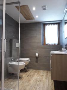 een badkamer met een wastafel, een toilet en een bad bij Appartamenti Florin in Livigno +19 foto's