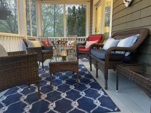 a screened porch with wicker chairs and a table at White Sails Inn in Kennebunk