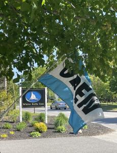 uma bandeira azul e branca em frente a um sinal em White Sails Inn em Kennebunk