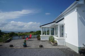 una casa bianca con patio con piante di Tower Beach a Galway