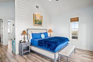 a bedroom with a blue bed and a window at Luxury house with wet bar, outdoor shower, steps from Gulf in Port Aransas