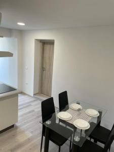 a dining room with a table and black chairs at Apartmaja Eva&Pia in Koper
