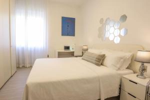 a white bedroom with a white bed and a window at FIORINA in Saronno