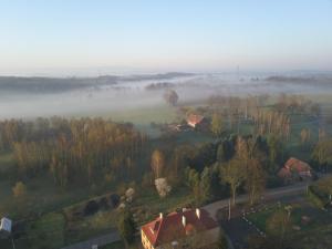 an aerial view of a foggy field with a house at Dom Mili in Henryków Lubański