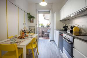 a kitchen with a table and yellow chairs in it at FIORINA in Saronno