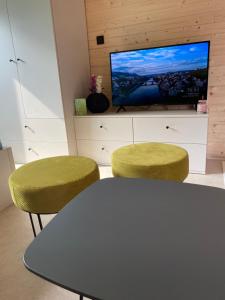 a room with a table and two chairs and a tv at Nevšední ubytování s privátním wellness in Lipence
