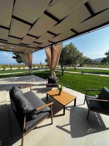 a patio with chairs and a table with a view of a field at •Naiades Villas• Odysseus• in Ladharió