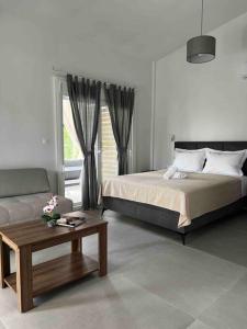 a bedroom with a bed and a coffee table at •Naiades Villas• Odysseus• in Ladharió