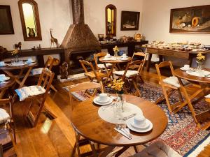 comedor con mesas y chimenea en Pousada Miraflores, en Campos do Jordão