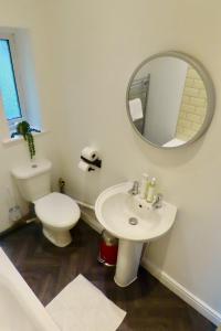 een badkamer met een toilet, een wastafel en een spiegel bij The King Stay in Manchester