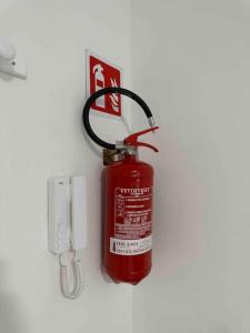 um extintor de incêndio está pendurado numa parede em Appartamento Luminoso Domus EUR em Roma