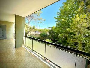 einen Balkon mit Blick auf den Fluss und die Bäume in der Unterkunft Appartamento Luminoso Domus EUR in Rom