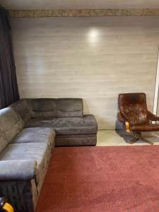 - un salon avec un canapé et une chaise dans l'établissement Садиба Райшток, à Staryy Mizunʼ