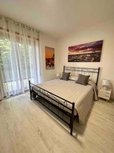 ein Schlafzimmer mit einem großen Bett in einem Zimmer mit Fenstern in der Unterkunft Appartamento Luminoso Domus EUR in Rom
