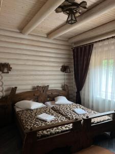 ein Schlafzimmer mit einem Holzbett und einem Deckenventilator in der Unterkunft VIP HOUSES Карпати Мигово in Myhowe
