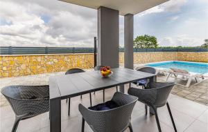 um pátio com uma mesa e cadeiras e uma piscina em Stunning Home In Pula With Outdoor Swimming Pool em Pula