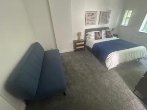 a bedroom with a bed and a blue chair at The King Stay in Manchester