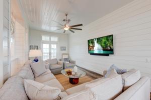 a living room with a couch and a tv on a wall at Blowfish Bungalow Rooftop Balcony, Boardwalk to Beach in Port Aransas