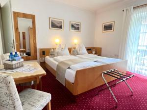 um quarto de hotel com uma cama grande e uma mesa em LANDHAUS luise em Bad Reichenhall